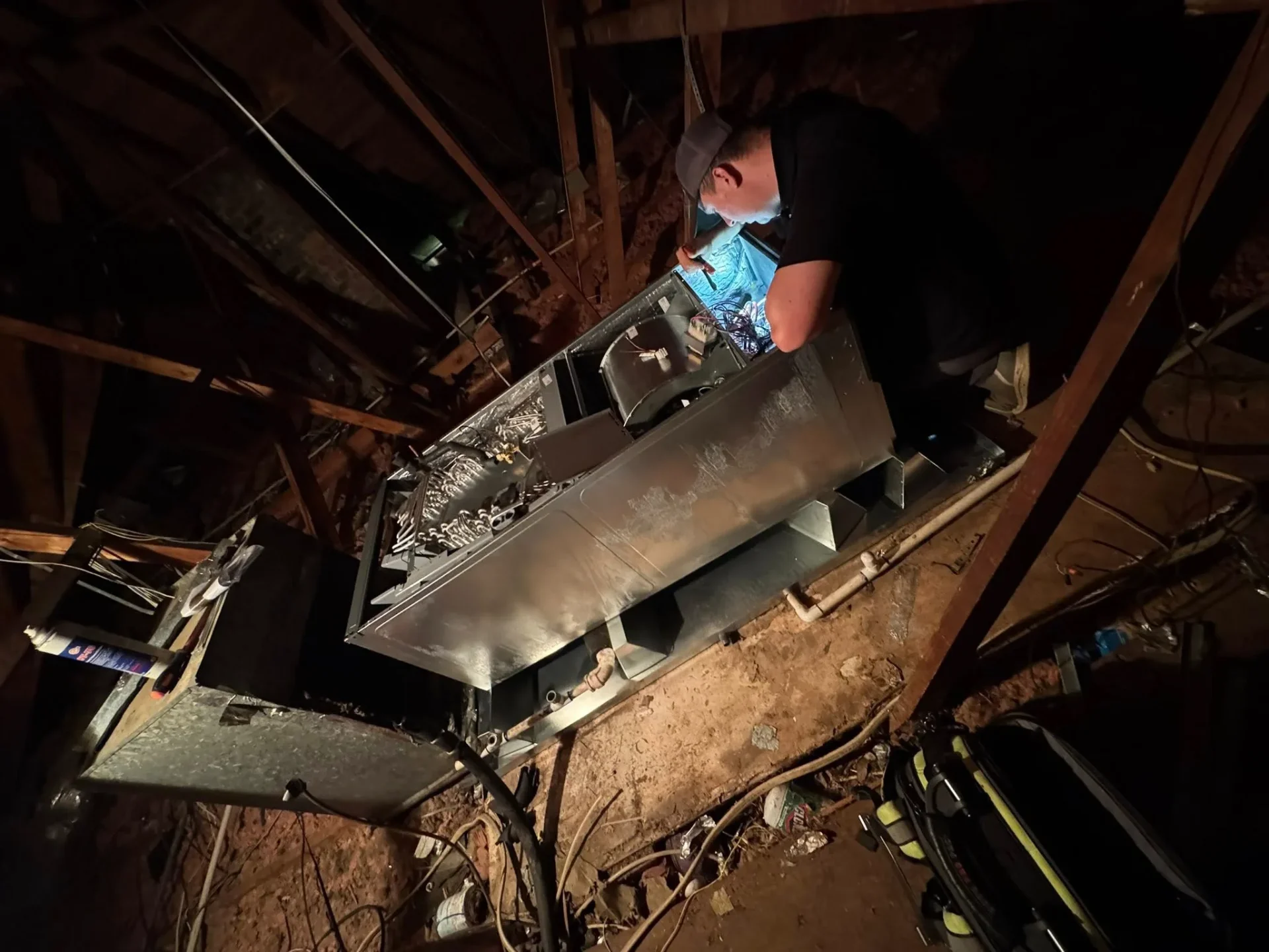 HVAC technician servicing attic air handler in Hammond, LA