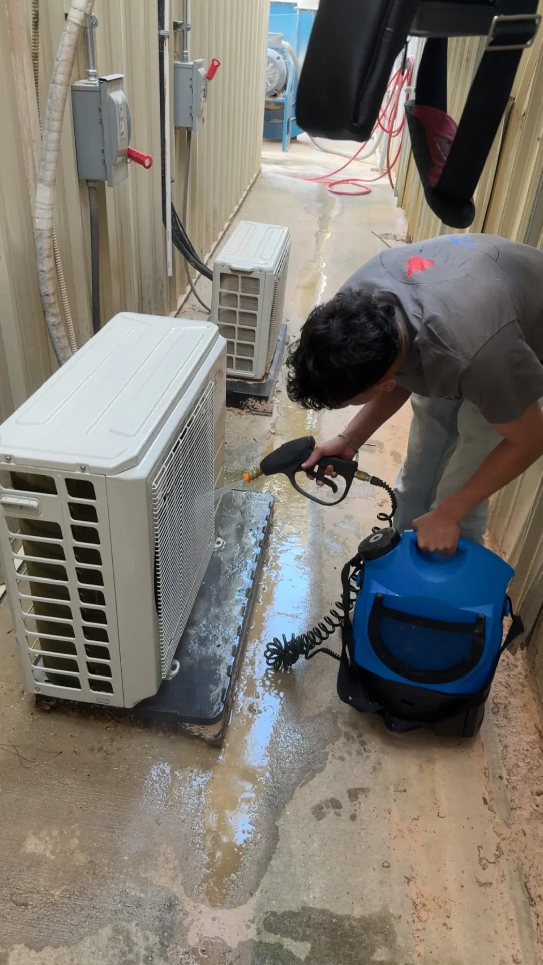 Technician cleaning outdoor AC unit during maintenance visit